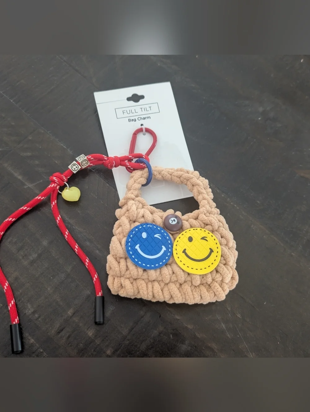 Full Tilt Beige Crochet Kids Bag Charm with Blue & Yellow Smiley Faces
